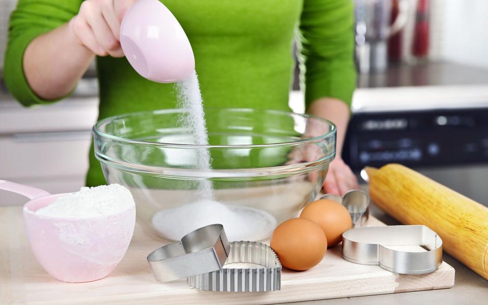 Person pouring sugar into a bowl - Credit: Alamy