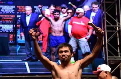 Manny Pacquiao shows off his candy snack at Friday's weigh-in. (AFP)