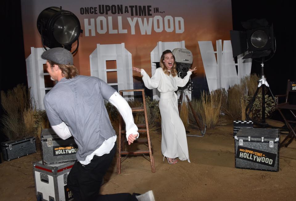 Australian actress Margot Robbie laughs as US actor Brad Pitt tries to photobomb her during the photo call for Sony Pictures' &quot;Once Upon a Time in Hollywood&quot; at the Four Seasons hotel on July 11, 2019 in Los Angeles. (Photo by Chris Delmas / AFP)        (Photo credit should read CHRIS DELMAS/AFP/Getty Images)