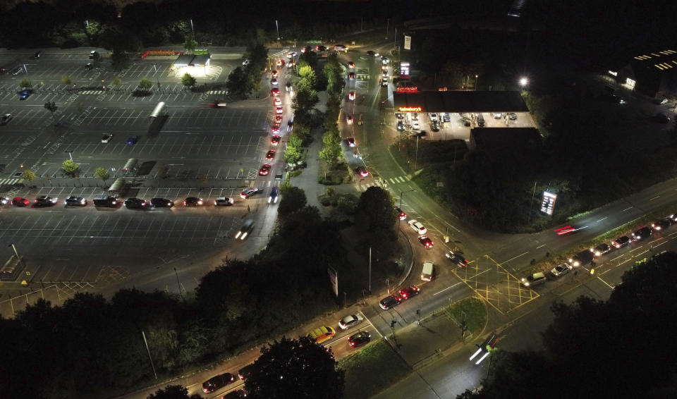 Motorists queue to fill their cars at a Sainsbury's fuel station in Ashford, England, Saturday, Sept. 25, 2021. The British government is expected to ease visa rules for truck drivers to help fix supply-chain problems that have triggered long lines at gas stations and some shuttered pumps. The government says it is“looking at temporary measures to avoid any immediate problems.” The haulage industry says the U.K. is short tens of thousands of truckers, due to a perfect storm of factors including the coronavirus pandemic, an aging workforce and an exodus of European Union workers following Britain’s departure from the bloc. (Gareth Fuller/PA via AP)