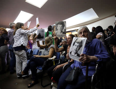 People hold up portraits of those who disappeared during Argentina's military dictatorship, as the sentence hearing of the five-year trial for the role of Navy officers during the 1976-1983 dictatorship is being held inside a courthouse in Buenos Aires, November 29, 2017. REUTERS/Marcos Brindicci