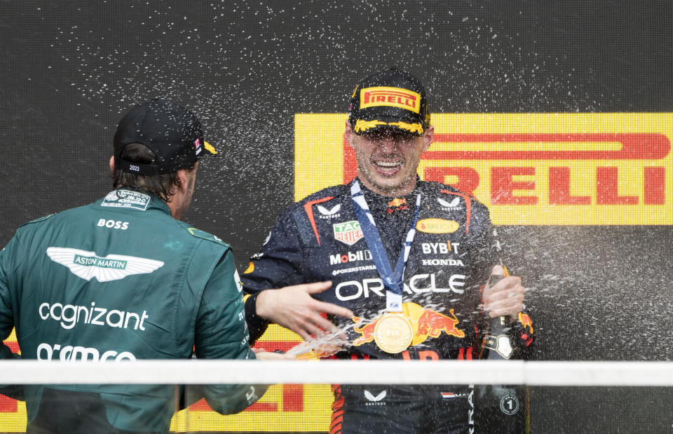 Winner Red Bull Racing's Max Verstappen, of the Netherlands, is sprayed with champagne by second place finisher Aston Martin driver Fernando Alonso, of Spain, during victory ceremonies following the Formula One Canadian Grand Prix auto race, Sunday, July 18, 2023, in Montreal. (Paul Chiasson/The Canadian Press via AP)