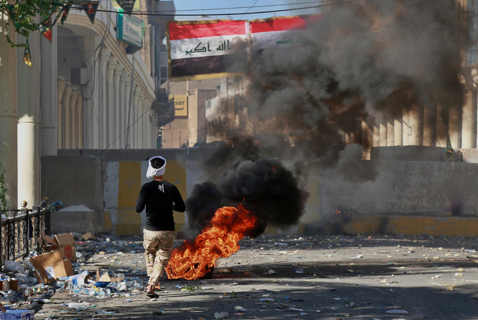 Anti-government protesters set fire during clashes between Iraqi security forces and anti-government protesters in the al-Rasheed street in Baghdad, Iraq, Friday, Nov. 8, 2019. The demonstrators complain of widespread corruption, lack of job opportunities and poor basic services, including regular power cuts despite Iraq's vast oil reserves. They have snubbed limited economic reforms proposed by the government, calling for it to resign. (AP Photo/Khalid Mohammed)