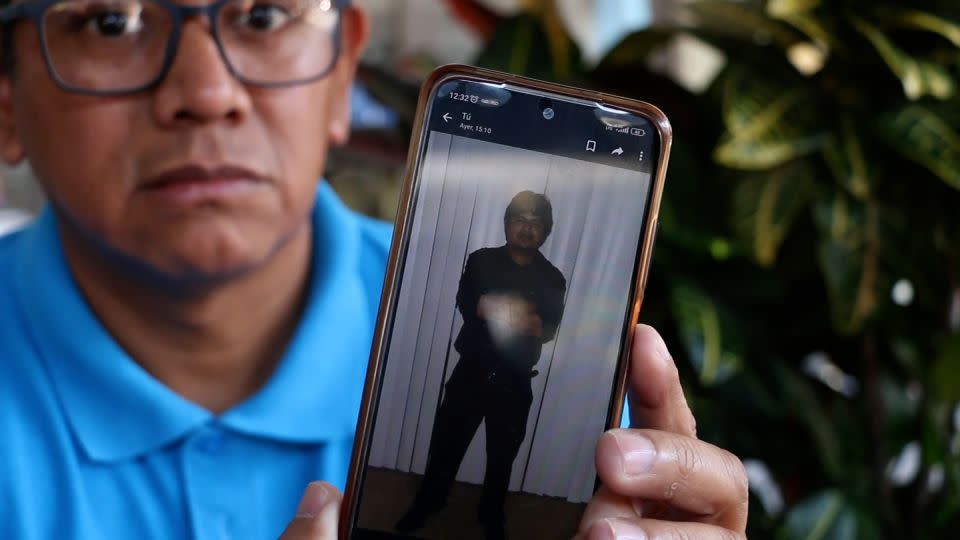 Wenceslao Contreras Ortiz holds a picture of his nephew Alejandro Hernandez Fuentes on his phone. - CNN