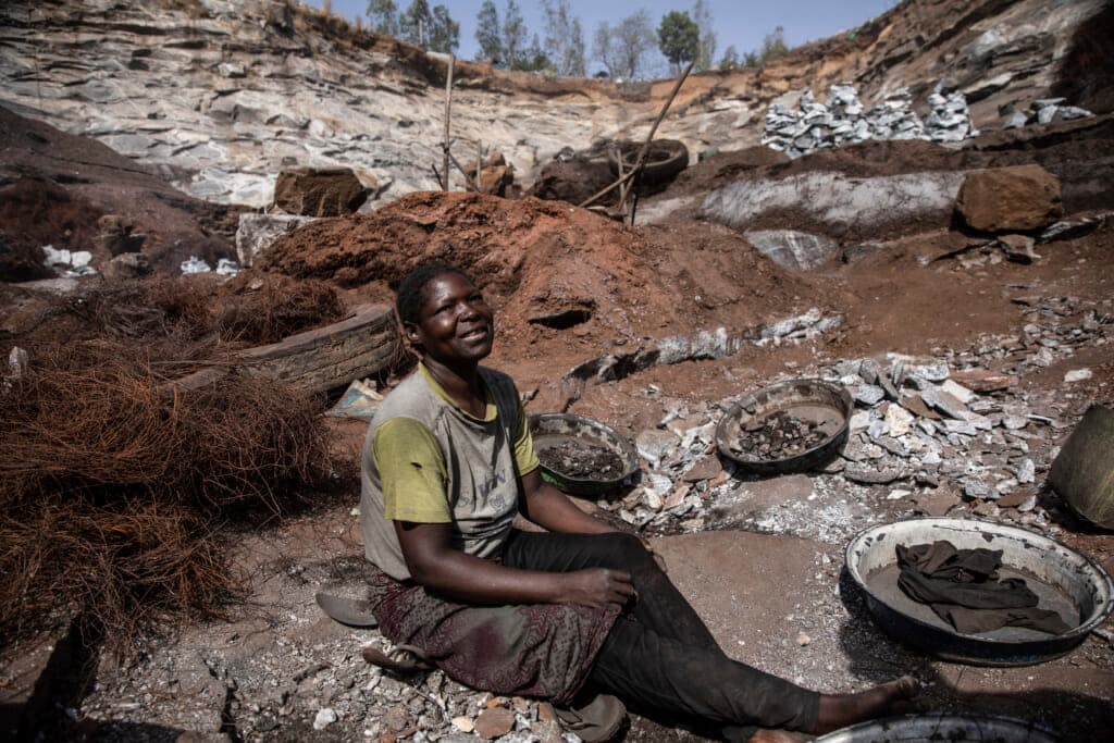 Ami Sana sits in the Pissy granite mine where she works in Ouagadougou, Burkina Faso, Wednesday April 27, 2022. The influx of people displaced by the country’s rapidly rising Islamic violence is causing competition among the approximately 3,000 people working at the granite mine. (AP Photo/Sophie Garcia)