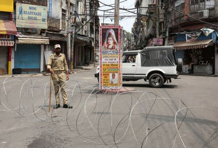 An Indian security personnel stands guard along a deserted street during restrictions in Jammu