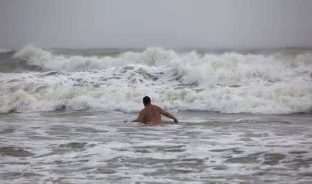 A swimmer waits for a large wave during the heavy surf of Hurricane Arthur, in Ocean Isle Beach, North Carolina July 3, 2014. REUTERS/Randall Hill