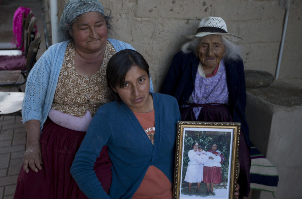 In this Aug. 23, 2018 photo, 117-year-old Julia Flores Colque Julia Flores Colque, behind right, poses for a photo with her grandniece Agustina Berna, left, and her great-grandniece Rosa Lucas at their home in Sacaba, Bolivia. In her long life, Julia has witnessed two world wars, revolutions in her native Bolivia and the transformation of her rural town of Sacaba from 3,000 people to a bustling city of more than 175,000 people in just five decades. (AP Photo/Juan Karita)