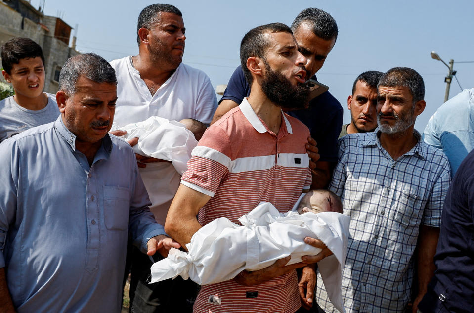 Mourners carry the bodies of twin Palestinian babies, who health officials said were killed along with their mother and three sisters in Israeli strikes, in the southern Gaza Strip on Sunday. (Ibraheem Abu Mustafa/Reuters)