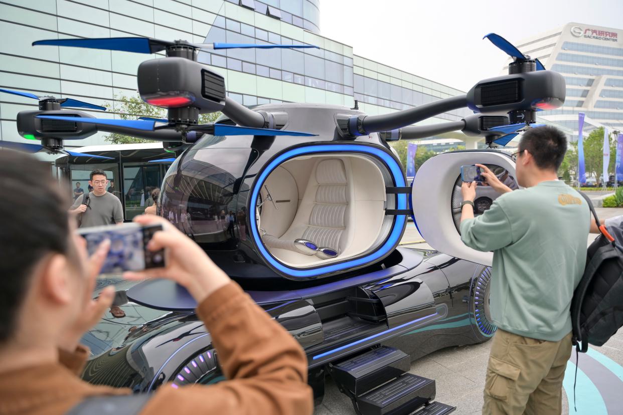 image of lfying car on display with people taking photos