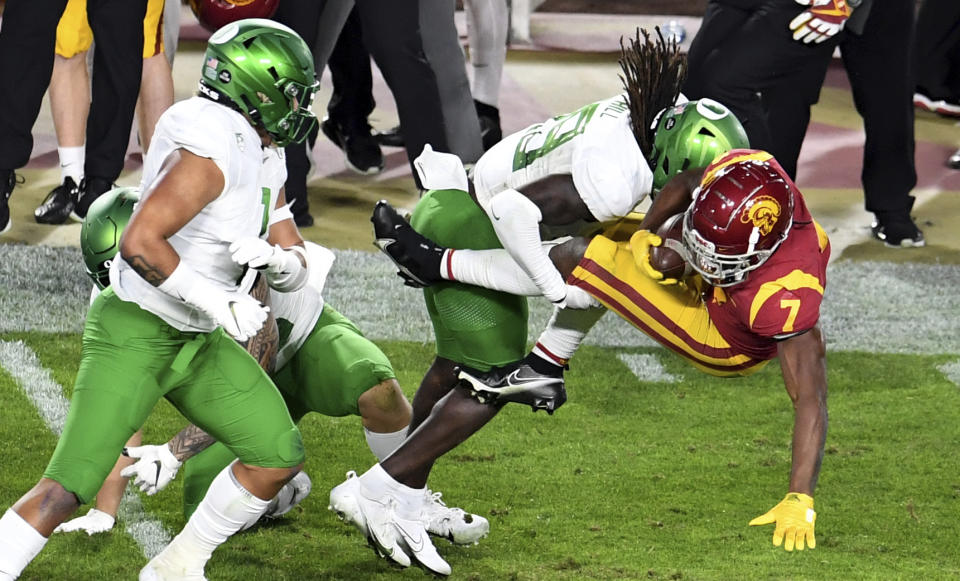 USC Running back Stephen Carr, right, runs for a first down and is tackled by Oregon safety Jamal Hill first half of an NCAA college football game at the Los Angeles Memorial Coliseum in Los Angeles on Friday, Dec. 18, 2020. (Keith Birmingham/The Orange County Register via AP)