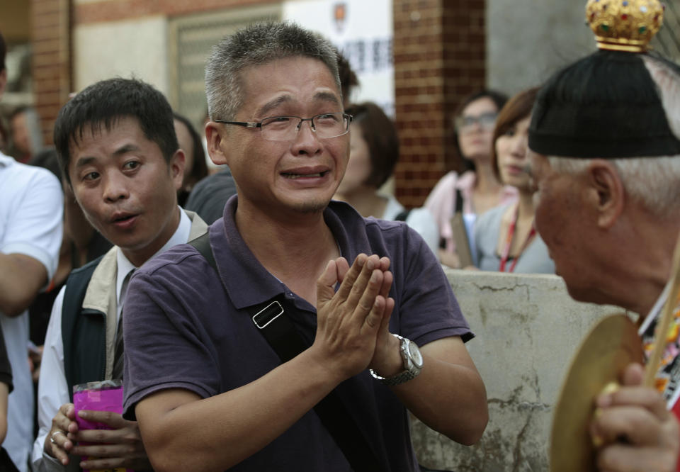 A relative of a victim killed in the TransAsia Airways Flight GE222 crash prays at a makeshift altar at the crash site on the outlying island of Penghu, Taiwan, Thursday, July 24, 2014. Stormy weather on the trailing edge of Typhoon Matmo was the likely cause of the plane crash that killed more than 40 people, the airline said Thursday. (AP Photo/Wally Santana)