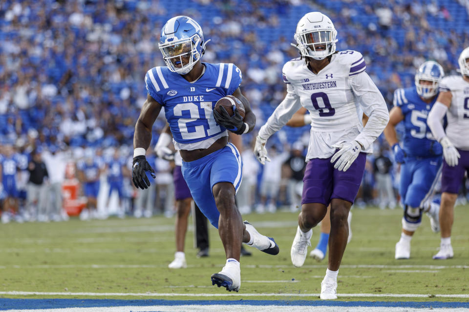 Duke's Peyton Jones (21) scores a touchdown ahead of Northwestern's Devin Turner (9) during the second half of an NCAA college football game in Durham, N.C., Saturday, Sept. 16, 2023. (AP Photo/Ben McKeown)