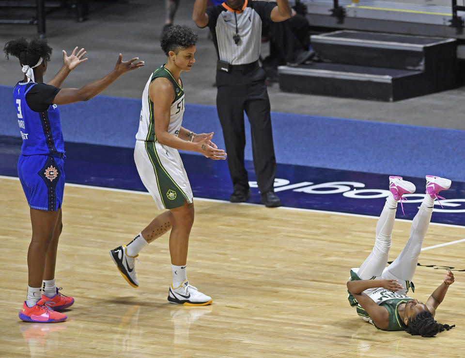 Connecticut Sun guard Kaila Charles, left, questions a call as Seattle Storm forward Candice Dupree, center, moves to help Storm guard Kiana Willams off the floor following a foul in the second half of a WNBA basketball game Sunday, June 13, 2021, at Mohegan Sun Arena in Uncasville, Conn. (Sean D. Elliot/The Day via AP)