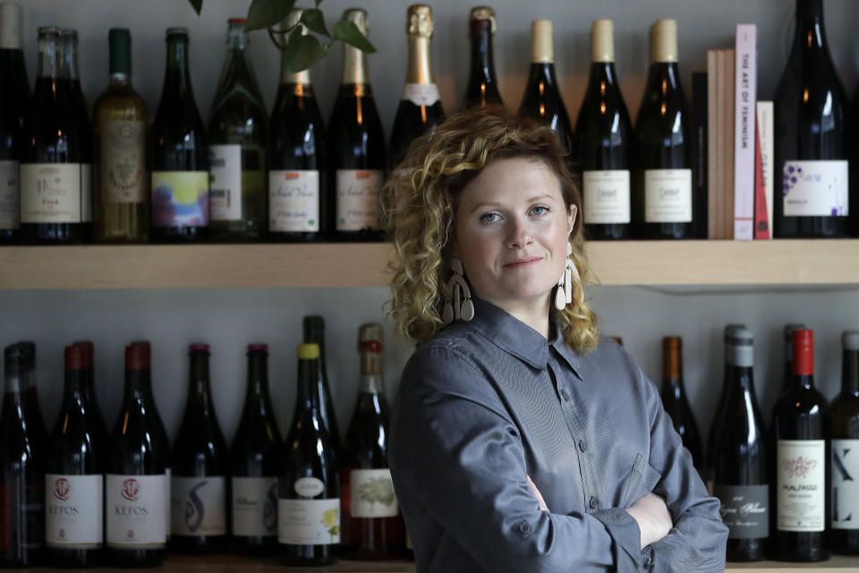 Lauren Friel, owner of Rebel Rebel Wine Bar, in Somerville, Mass., stands for a portrait at the wine bar, Thursday, April 2, 2020. An Associated Press review of the small business aid passed by Congress as part of its coronavirus stimulus package shows that larger companies could quickly claim a disproportionate share of the money, squeezing out many small, locally-based businesses. (AP Photo/Steven Senne)