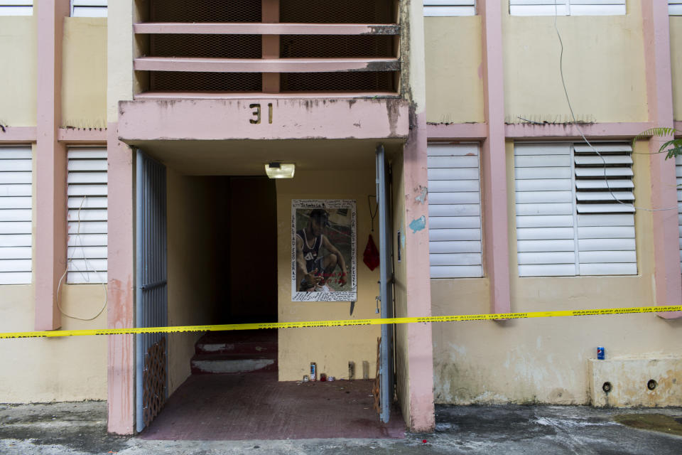 Police tape secures the area of a makeshift altar at the home of a youth that was murdered on Sept. 11, at the scene of a multiple killing in San Juan, Puerto Rico, Tuesday, Oct. 15, 2019. Several people are reported dead following a shooting in the Rio Piedras neighborhood of San Juan. (AP Photo/Dennis M. Rivera Pichardo)