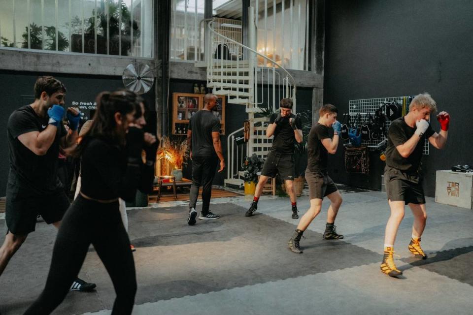 Asa Watson (middle, all black with back turned) gives instruction during a boxing class at Fontana Klub in Frankfurt.