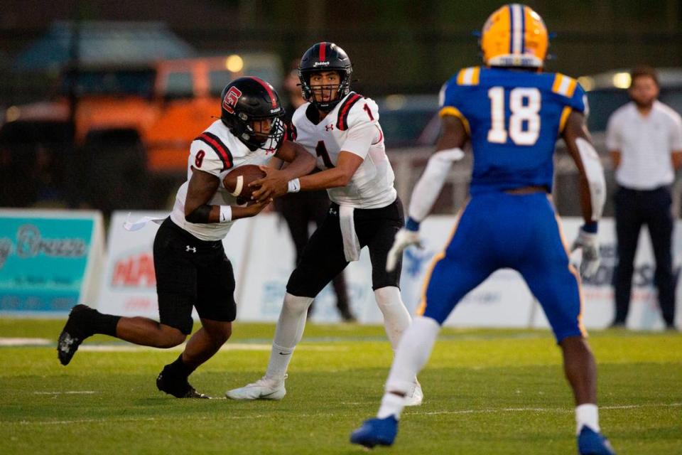 St. Stanislaus quarterback Ian Gael Gonzalez Rioz passes the ball off to Joshua Hartl during a game at Bay High in Bay St. Louis on Friday, Sept. 1, 2023.