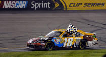 RICHMOND, VA - APRIL 28: Kyle Busch, driver of the #18 M&M's Ms. Brown Toyota, celebrates with the checkered flag after winning the NASCAR Sprint Cup Series Capital City 400 at Richmond International Raceway on April 28, 2012 in Richmond, Virginia. (Photo by Drew Hallowell/Getty Images)