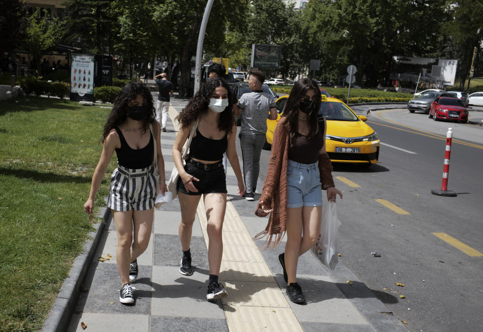 Young women walk along a street as a temperature of 36 degrees celsius hits the Turkish capital, Ankara, Friday, July 2, 2021. Turkish health-care workers and people aged over 50 has started to get a third dose of vaccines, Pfizer-BioNTech or China's Sinovac.( Photo/Burhan Ozbilici)