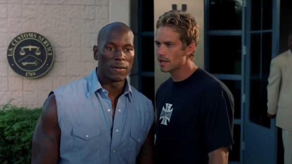 Tyrese Gibson and Paul Walker standing outside of an office building in 2 Fast 2 Furious.