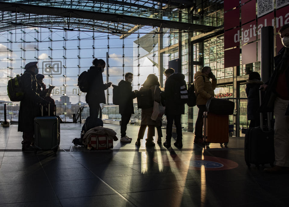 People wait in front of the travel desk of German railway Deutsche Bahn at Central Station in Berlin, Germany, Thursday, Feb. 17, 2022. Deutsche Bahn has suspended long-distance services in some German regions because of the weather situation. (Paul Zinken/dpa via AP)