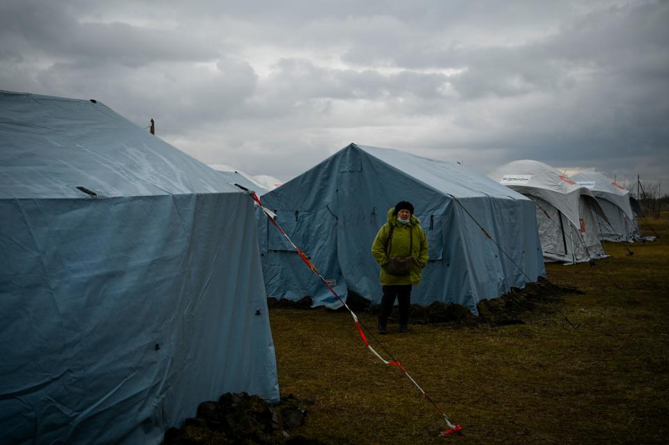 A woman stands in front of a tent at a refugee camp set up on the former football stadium of the town of Palanca, near the Moldova-Ukraine border checkpoint, on March 2, 2022, seven days after Russia' military invasion of Ukraine. (Nikolay Douchinov/AFP via Getty Images)