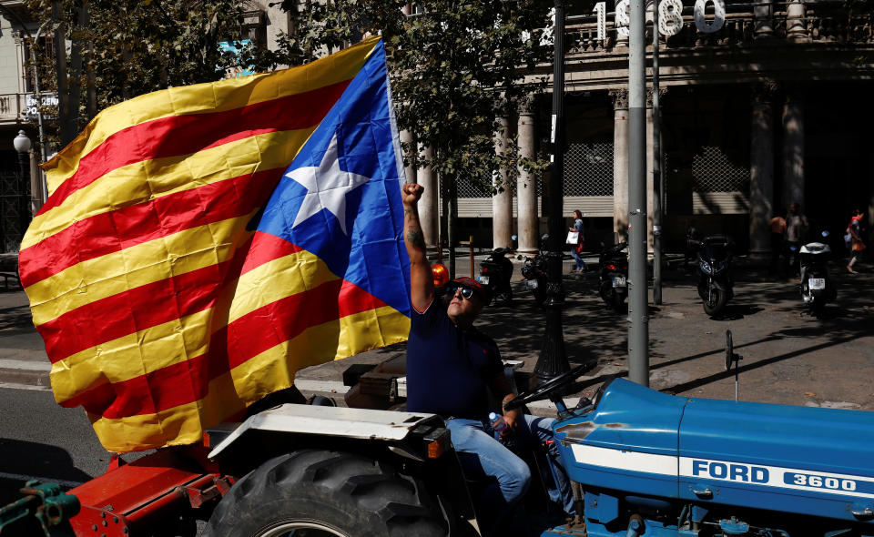 <p>A farmer raises his fist at an overflying police helicopter while driving his tractor in a protest to show support for the banned referendum on independence from Spain in Barcelona, Spain, Sept. 29, 2017. (Photo: Juan Medina/Reuters) </p>