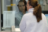 A woman exchanges her currency as a small sign shows the exchange rate at a bureau de change in London, Tuesday, Sept. 27, 2022. The pound slumped to its lowest level against the dollar since 1971, after the Chancellor hinted more tax cuts would follow those he announced last week. (AP Photo/Frank Augstein)