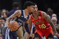 Memphis Grizzlies guard Ja Morant (12) handles the ball against Atlanta Hawks guard Jeff Teague (00) in the first half of an NBA basketball game Saturday, March 7, 2020, in Memphis, Tenn. (AP Photo/Brandon Dill)