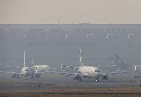 Passenger planes are pictured in formation ready to take off at Mexico City's international airport as Mexico authorities declared an environmental emergency on Tuesday for metropolitan Mexico City, as smoke from nearby wildfires pushed pollution to levels deemed potentially harmful to human health, in Mexico City, Mexico May 14, 2019. REUTERS/Luis Cortes