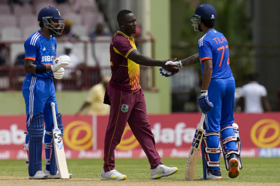 India's Tilak Varma, right, shakes hands with West Indies' captain Rovman Powell at the end of their third T20 cricket match at Providence Stadium in Georgetown, Trinidad and Tobago, Tuesday, Aug. 8, 2023. India won by 7 wickets. (AP Photo/Ramon Espinosa)