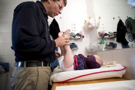 Peter Talos changes the diapers of his daughter Karin, as they spend time together during his parental leave, in Oslo, October 5, 2012. REUTERS/Heiko Junge/NTB Scanpix