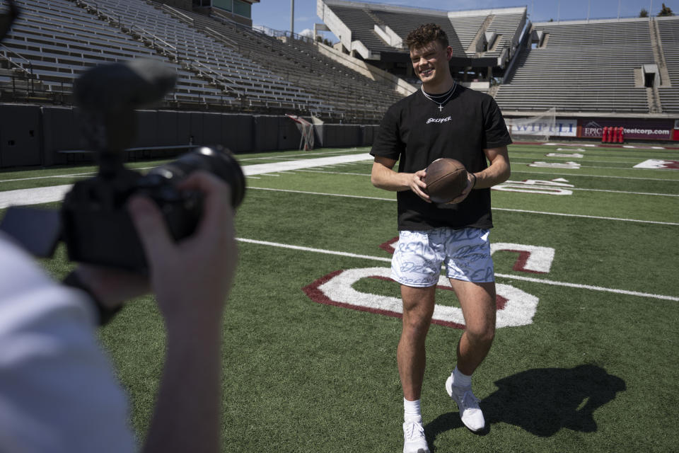 Adam Botkin a football TikTok influencer, records a video for a post at Washington-Grizzly Stadium in Missoula, Mont., on Monday, May 1, 2023. Botkin, a former walk-on place kicker and punter for the Montana Grizzlies, gained notoriety on the social media platform after videos of him performing kicking tricks went viral. Montana became the first state in the U.S. to completely ban TikTok on Wednesday, May 17, when Republican Gov. Greg Gianforte signed a measure that's more sweeping than any other state's attempts to curtail the social media app. (AP Photo/Tommy Martino)