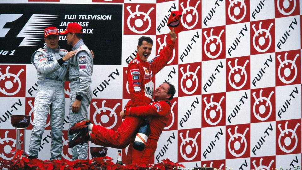 Michael Schumacher jumps in the arms of Ferrari team principal Jean Todt after winning the 2000 Formula 1 World drivers' Championship.