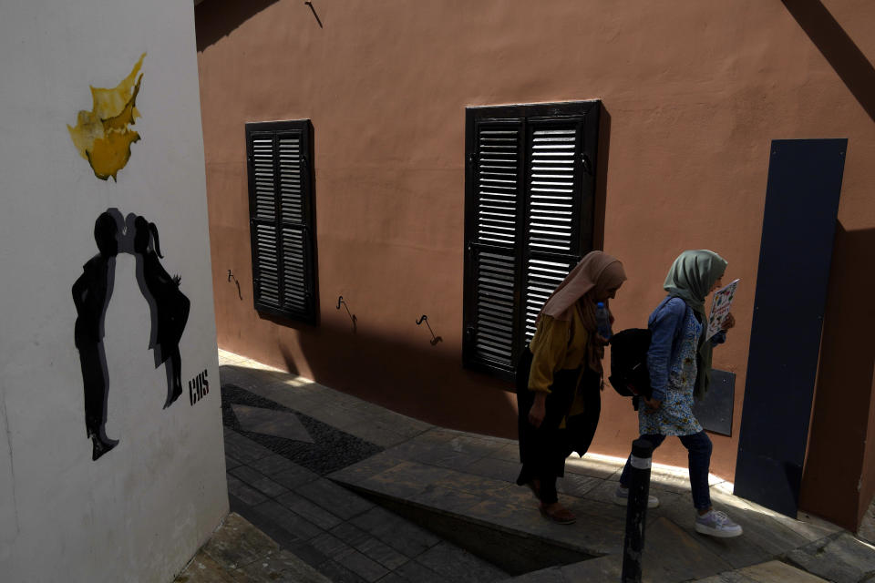 FILE - Migrants walk inside the medieval core at the old city of the divided capital Nicosia, Cyprus, Wednesday, May 10, 2023. Cyprus has formally called on the European Union to re-evaluate which areas of Syria can be declared as safe zones that are free from armed conflict so that Syrian migrants can eventually be repatriated there. (AP Photo/Petros Karadjias, Files)