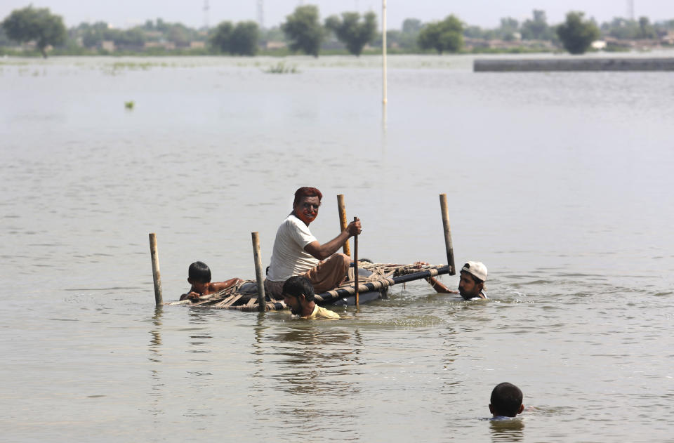 People use cot to salvage belongings from their nearby flooded home caused by heavy rain in Jaffarabad, a district of Pakistan's southwestern Baluchistan province, Saturday, Sep. 3, 2022. The homeless people affected by monsoon rains triggered devastating floods in Pakistan get enhancing international attention amid growing numbers of fatalities and homeless families across the country as the federal planning minister appealed the international community for immense humanitarian response for 33 million people. (AP Photo/Fareed Khan)