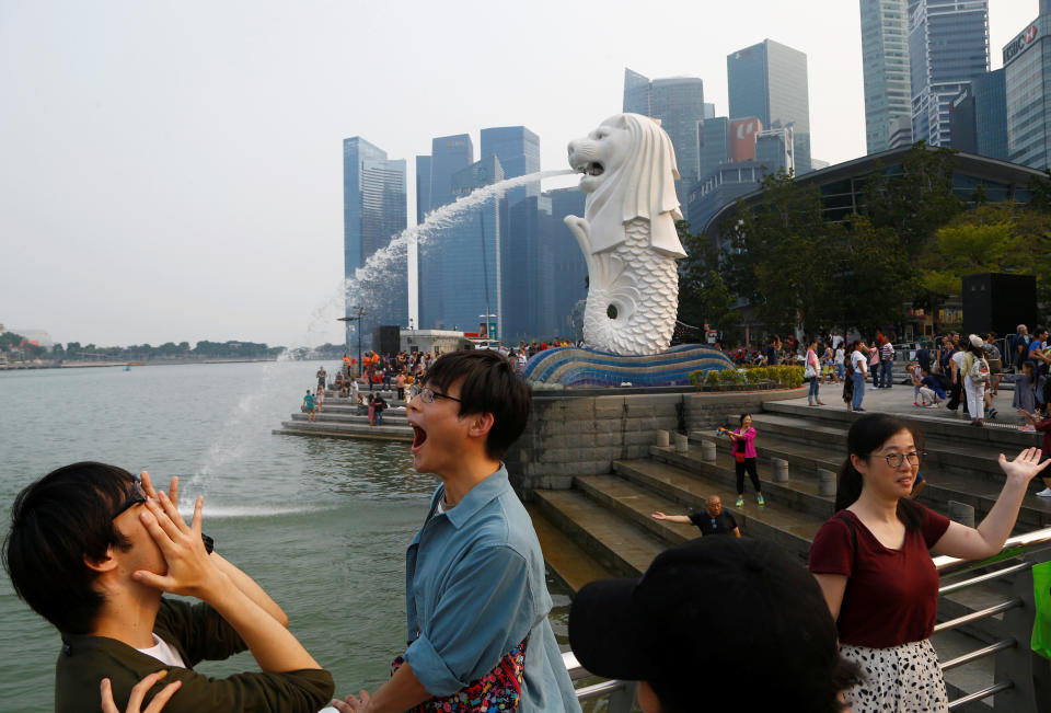 Tourists take photos with the Merlion on a hazy day in Singapore September 13, 2019. REUTERS/Feline Lim