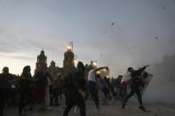Demonstrators throw rocks at the National Palace during a march to commemorate International Women's Day and protesting against gender violence, in Mexico City, Monday, March 8, 2021. (AP Photo/Rebecca Blackwell)