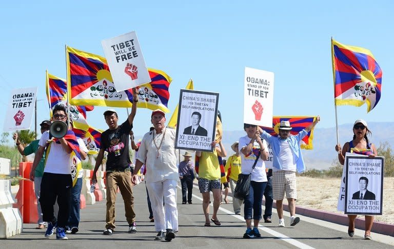 Protesters shout slogans in a cordoned off protest zone across from the venue for talks between US President Barack Obama and his Chinese counterpart Xi Jinping in the California desert community of Rancho Mirage, California, on June 7, 2013. Several hundred protesters jeered Xi, including members of the banned Falungong spiritual movement and Tibetans who chanted, "China, get out of Tibet!"