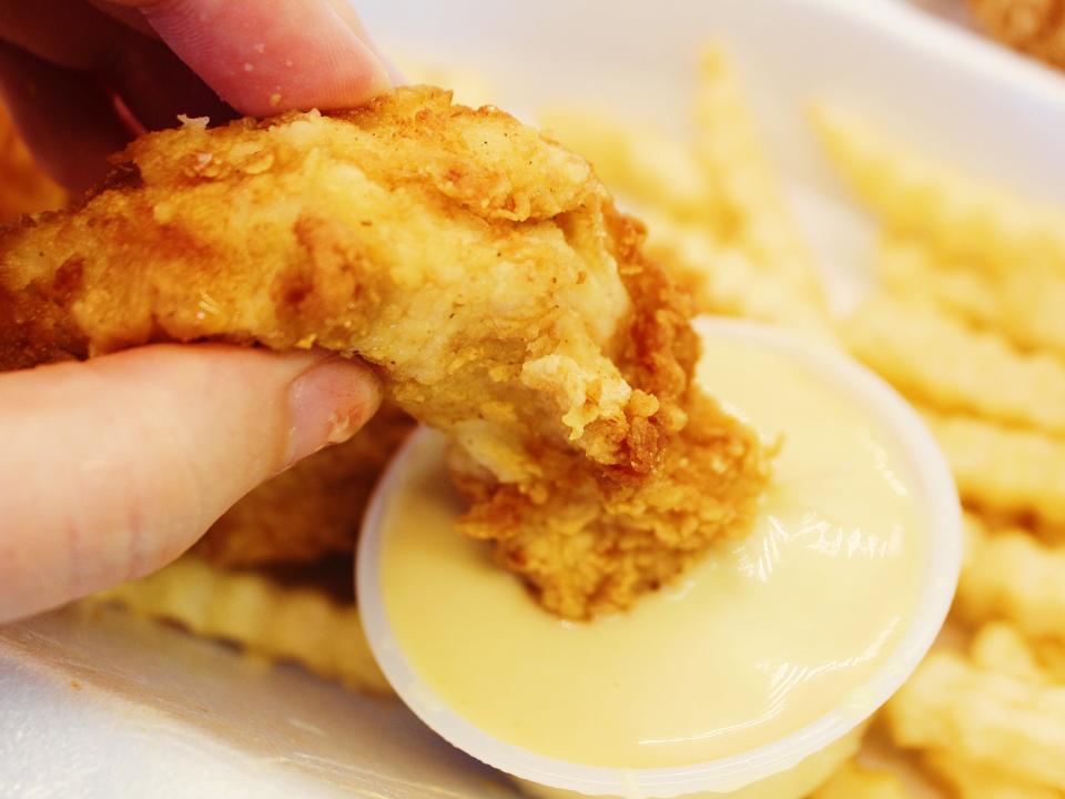 raising canes chicken tender dipped in honey mustard