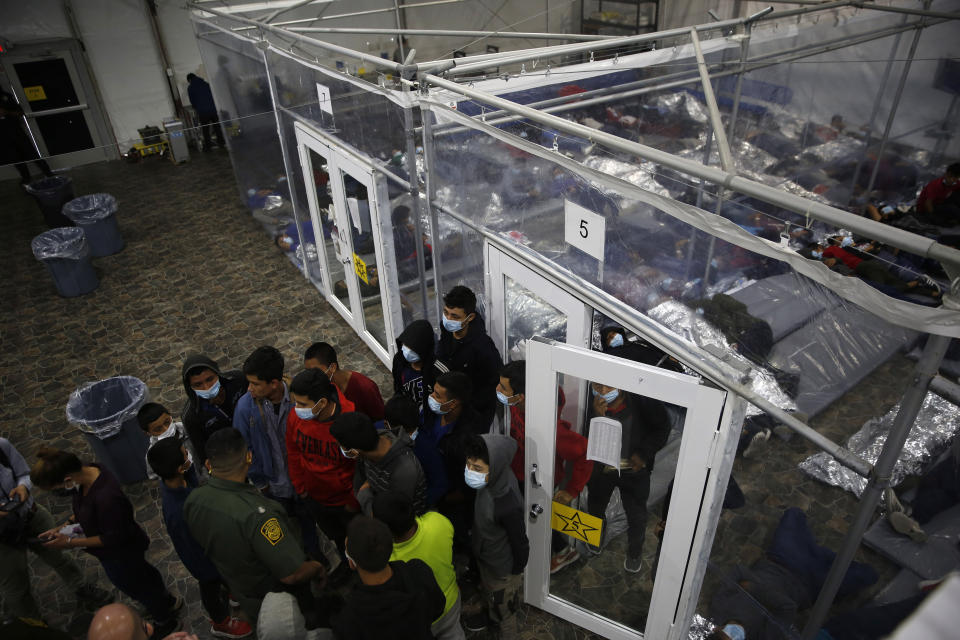 Minors talk to an agent outside a pod at the Department of Homeland Security holding facility run by the Customs and Border Patrol (CBP) on March 30, 2021 in Donna, Texas. The children are housed by the hundreds in eight pods that are about 3,200 square feet in size. Many of the pods had more than 500 children in them. (Dario Lopez-Mills - Pool/Getty Images)