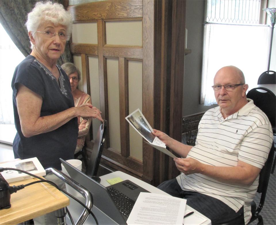 Dee Ann Lemon (left), the daughter of Homer Hott, and Holmes County Historical Society Executive Director Mark Boley go      over photos and other information while putting together a presentation on Holmesville's Homer Hott Goes to Hollywood.  The presentation will be Thursday July 28 at the Holmesville Church of Christ.