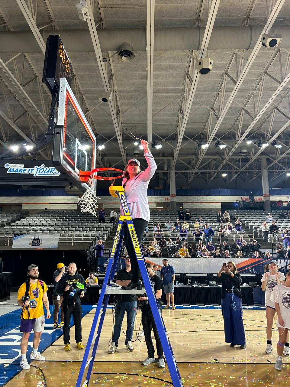 Genoa grad Amy Sander holds her piece of the net as associate coach for Minnesota State University-Mankato women's basketball.