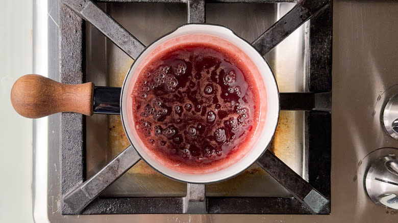 Raspberry sauce simmering in saucepan on stovetop