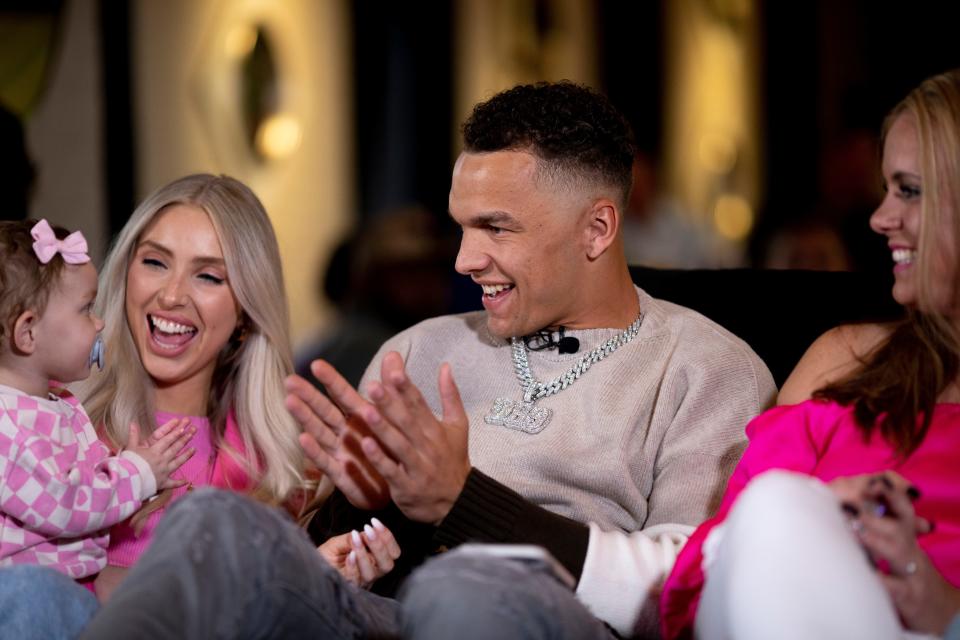 Desmond Ridder, former UC quarterback, claps with his daughter, Leighton, 1, who is held by his girlfriend, Claire Cornett, while they watch the 2022 NFL Draft at his draft party in Louisville, Ky., on Friday, April 29, 2022. Ridder was surrounded by about 100 friends and family. 