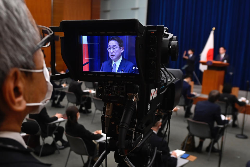 Japan's Prime Minister Fumio Kishida is seen on tv camera screen during his press conference at the prime minister's official residence in Tokyo, Friday, Dec. 16, 2022. In a major break from its strictly self-defense-only postwar principle, Japan adopted a national security strategy Friday declaring plans to possess preemptive strike capability and cruise missiles within years to give itself more offensive footing against threats from neighboring China and North Korea. (David Mareuil/Pool Photo via AP)