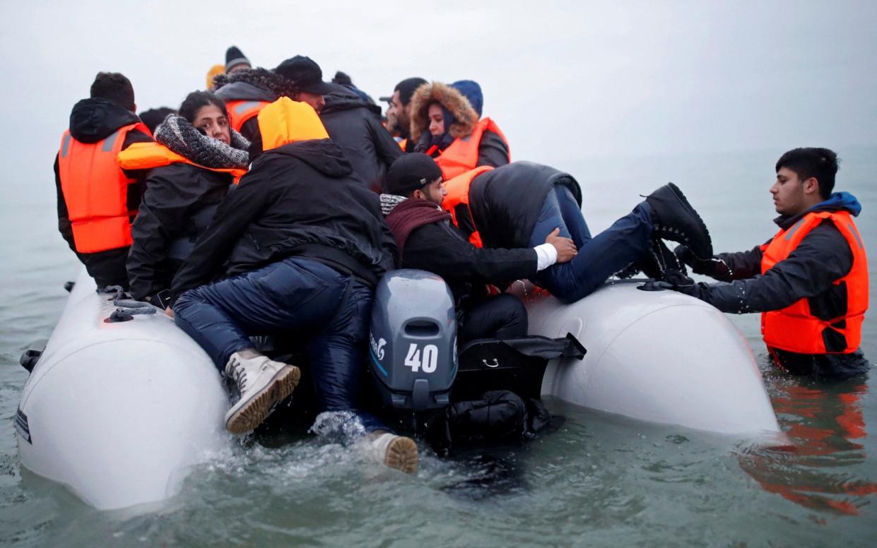 Migrants get on an inflatable dinghy, as they leave the coast of northern France to cross the English Channel, in Wimereux, near Calais, France, - Reuters