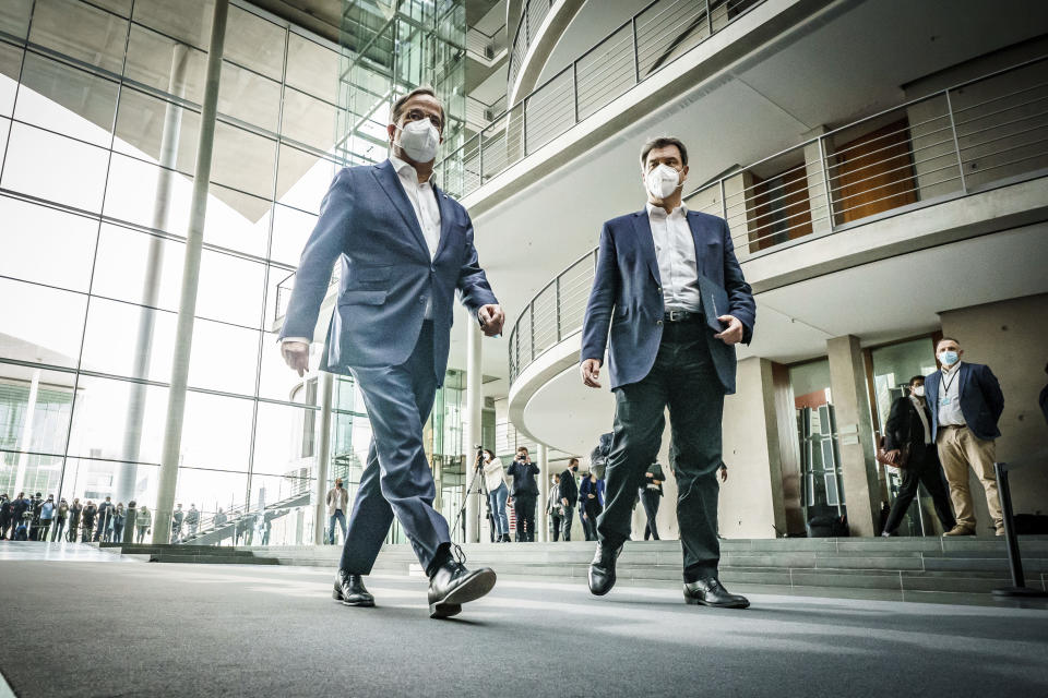 The chairman of the German Christian Democratic Party (CDU), ArminLaschet, left, and the chairman of the German Christian Social Union (CSU), Markus Soeder, right, arrive for a statement folowing a closed meeting of the federal palrliament factions of both partys in Berlin, Germany, Sunday, April 11, 2021. The two party chairmen and German state governors want to become the center-right candidate for the country's Sept. 26 national election, the German news agency dpa reported Sunday. (Michael Kappeler/dpa via AP)