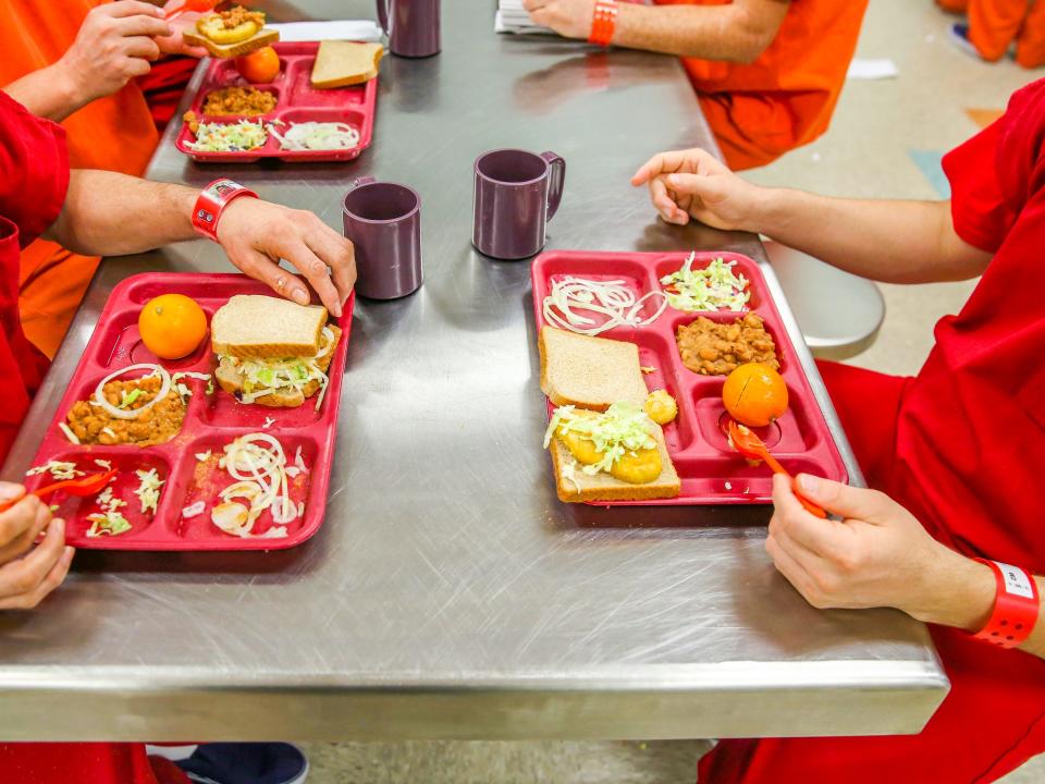 ADELANTO, CA - NOVEMBER 15: Immigrant detainees eat lunch, one of three meals a day at the Adelanto Detention Facility on November 15, 2013 in Adelanto, California. The facility, the largest and newest Immigration and Customs Enforcement (ICE), detention center in California, houses an average of 1,100 immigrants in custody pending a decision in their immigration cases or awaiting deportation. The average stay for a detainee is 29 days. The facility is managed by the private GEO Group. ICE detains an average of 33,000 undocumented immigrants in more than 400 facilities nationwide. (Photo by John Moore/Getty Images)